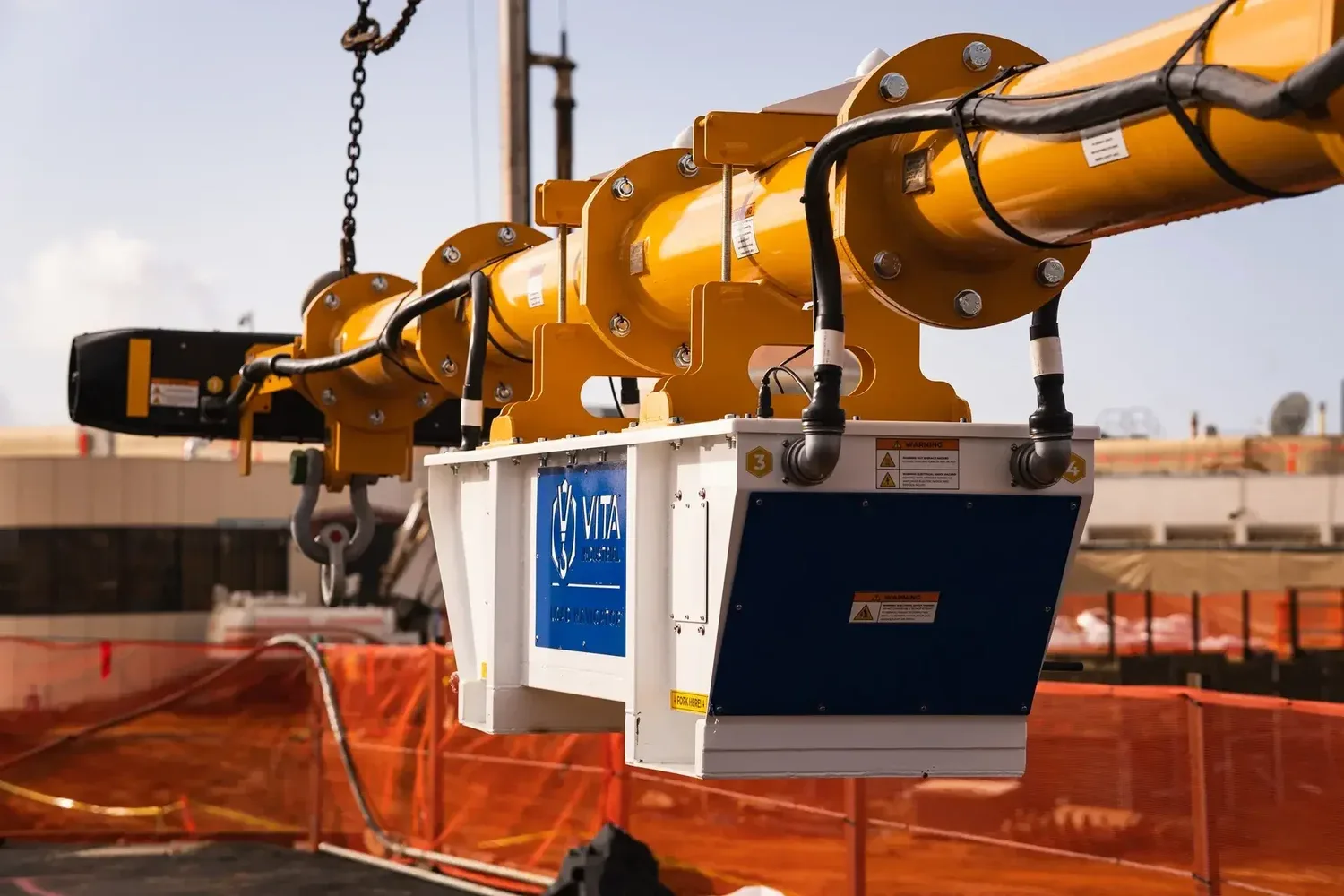 Vita Load Navigator suspended beneath a crane hook on a construction site